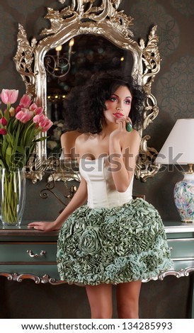 Coquette. Curly Hair Woman in Elegant Dress over Vintage Mirror