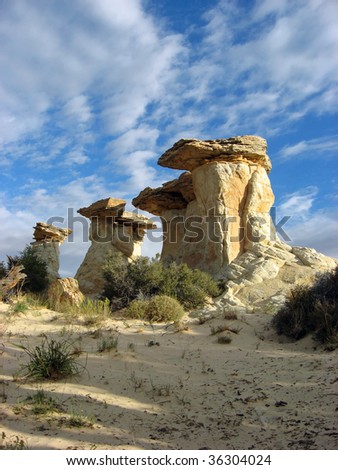 A small group of sandstone hoodoos in a remote desert area.