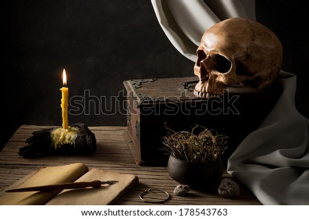 still life photography, human skull with old wooden box, Lighted candle and old book