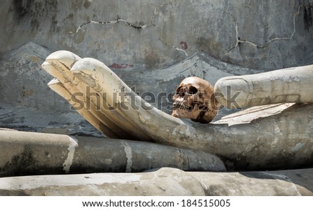 human skull on old big stucco buddha statue hand in good and evil concept