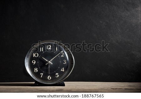 old alarm clock on old wood plank with dark grunge background