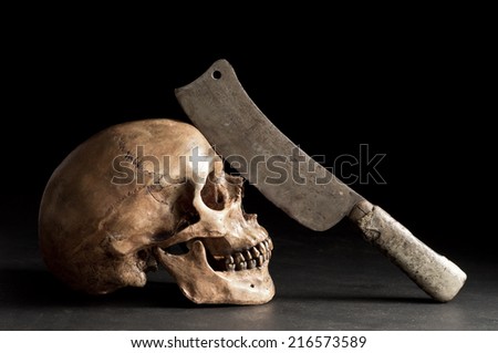 still life photography, human skull with old knife on his forehead