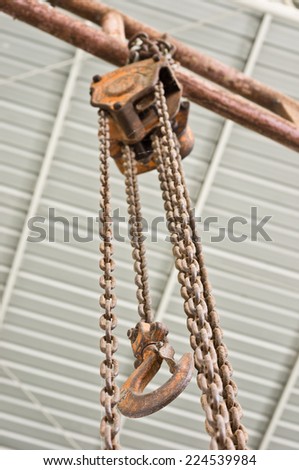 old and rusty Industrial chain pulley and hook is hanging