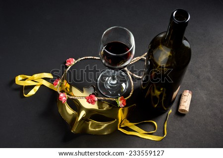 still life photography : wine bottle and glass with mask and flower necklace in fancy party concept
