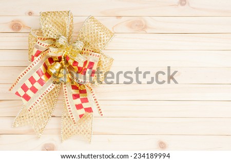 element of golden net ribbon, tinsel ribbon and golden bell on pine wood background with space