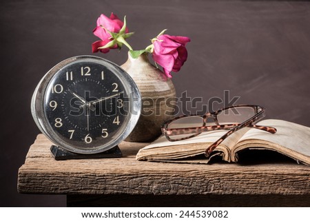 Still life photography : old clock, old book, glasses and rose in vase on waiting love concept
