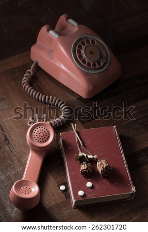 still life photography : old abandon telephone, old book, dry rose, with sedative in commit suicide concept