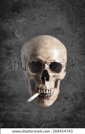 mix up of grunge background with human skull smoking the cigarette with some smoke in vintage color tone