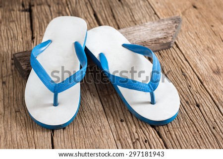 used white and blue rubber slippers on old wood