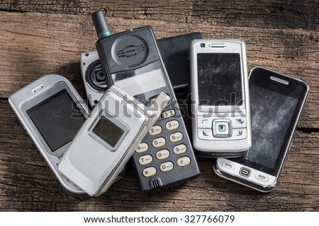 Old and obsolete mobile phone on old wood