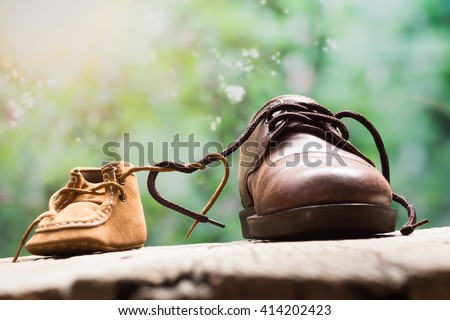 father and child shoes tie the shoestring together in heart shape, love and bound concept