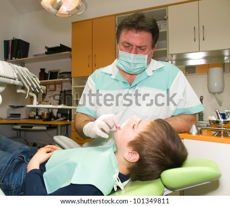 Dentist and young boy in exam room