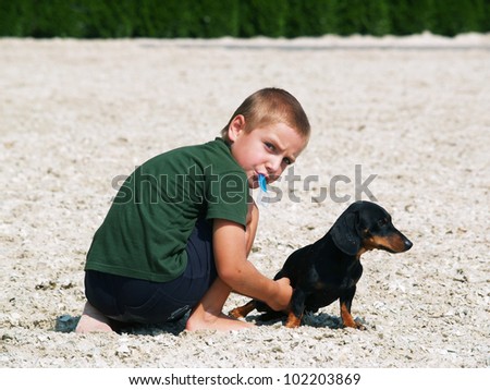 Boy with ice-cream playing with dog