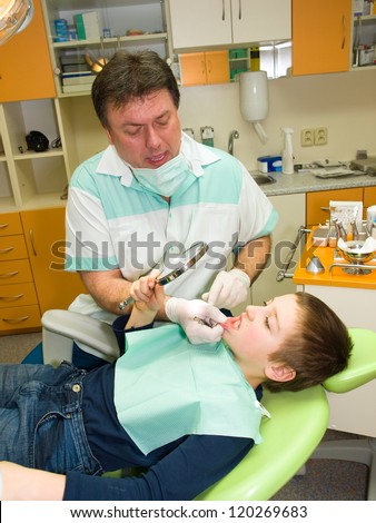 Dentist and young boy in exam room