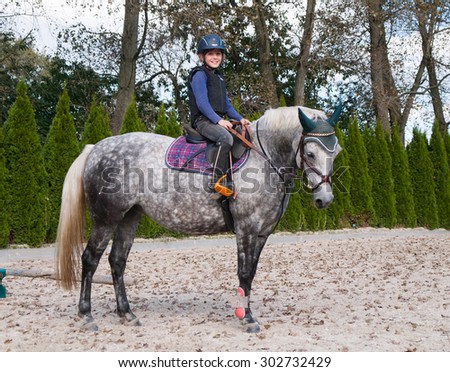 Girl training riding on sport pony