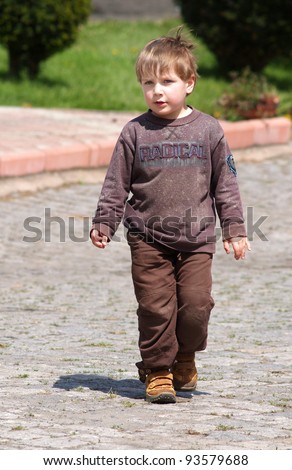 Little boy walking the street