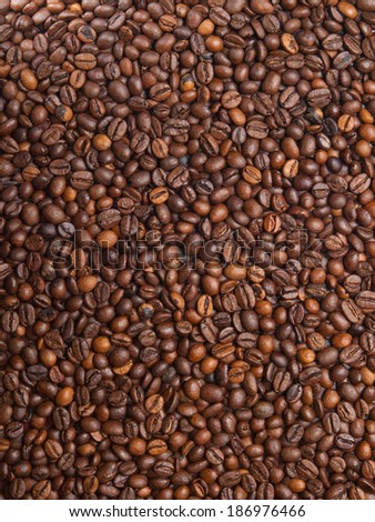 Numerous coffee beans which have been scattered all over the surface