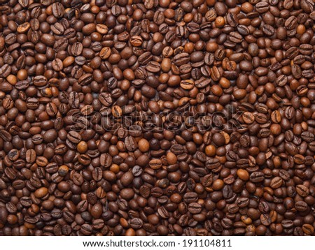 Numerous coffee beans which have been scattered all over the surface