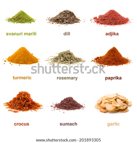 Heap ground Svanuri marili, dill seed, adjika, turmeric, rosemary, paprika, saffron, sumach and garlic isolated on white background