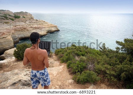 boy working on portable pc in the coast