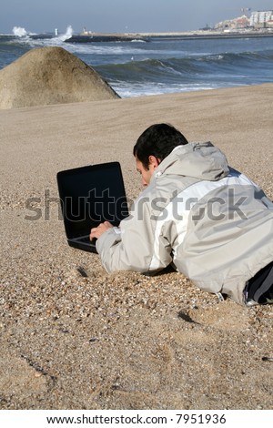man working on portable pc on the beach