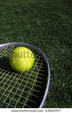 A tennis racket and tennis ball, sports photo