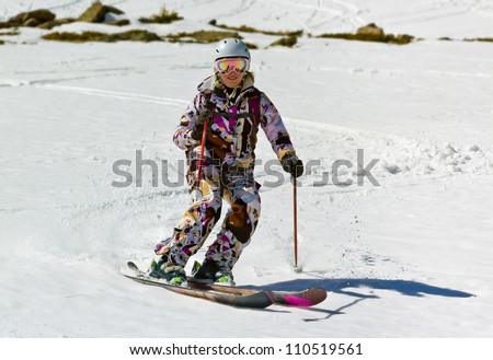 Woman skier descends the steep slope in deep snow in the sun.