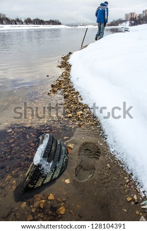 Travel along the shore of the river. Garbage pollution in the city. Can't freeze the river in winter