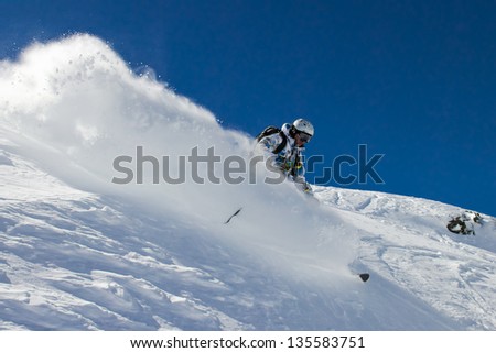 Skier in deep snow. In turn raises the snow dust.