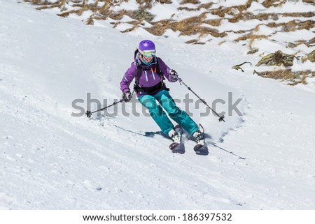 Female skier on the border of snow. Off-piste skiing in soft snow.