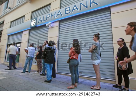 GREECE, Thessaloniki JUNE 28, 2015: Citizens line up to use an automated teller machine (ATM) outside a closed bank. Cash machines ran dry after Greeks rushed to withdraw their savings from the banks.