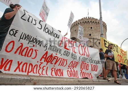 GREECE, Thessaloniki JUNE 29, 2015: Supporters of the NO vote in the upcoming referendum protest holding banners reading NO (OXI in greek) during a rally around the White Tower in Thessaloniki