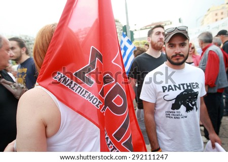 GREECE, Thessaloniki JUNE 29, 2015: Supporter of the NO vote in the upcoming referendum protest holding a Syriza party flag during a rally around the White Tower in Thessaloniki