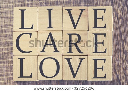 Live Care Love message formed with wooden blocks. Cross processed image for retro look