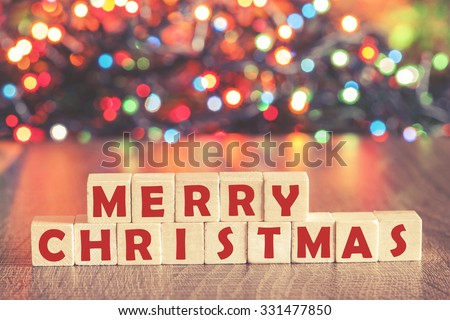 Christmas concept with Merry Christmas wish formed on wooden blocks and defocused bokeh Christmas lights background