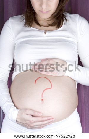 Painted red question mark on the belly of pregnant woman