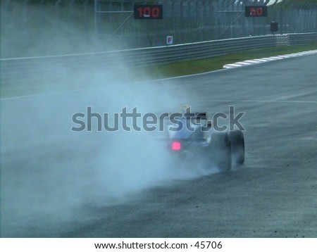 Formula race car splashing through a wet track