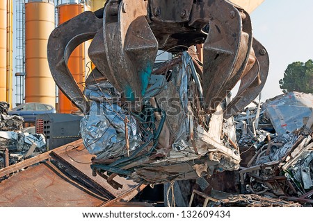 mechanical arm at work in a car wrecker
