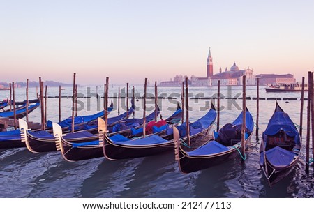 covered gondolas in Venice lagoon at sunset
