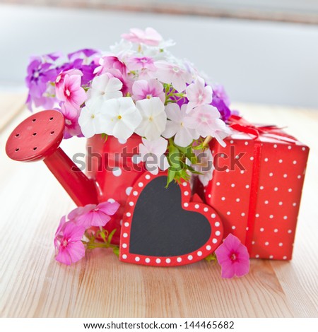 Colorful fresh flowers and a little present wrapped in dotted paper