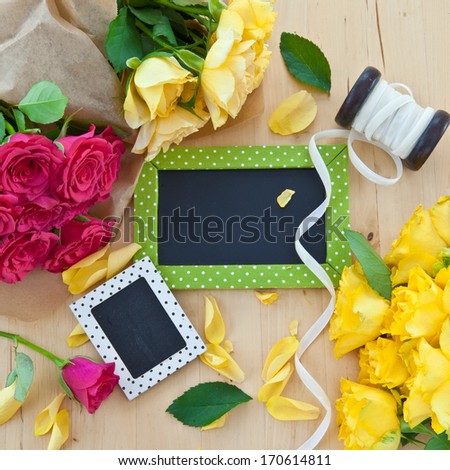 Yellow and pink roses and a little blackboard with copy space