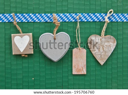 Little heart-shaped tags on green wooden background