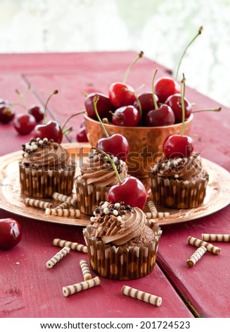 Chocolate cream cupcakes with fresh red cherries