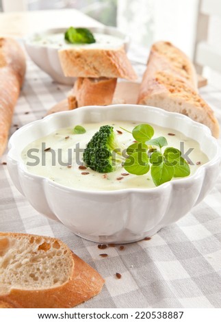Homemade creamy broccoli soup and fresh baguette
