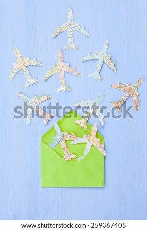 Green envelope with Paper planes made from vintage maps on blue