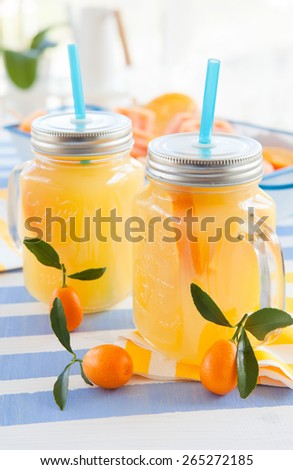Orange juice in vintage jars with fresh kumquats