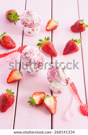 Ice cream with fresh strawberries on pink wooden boards
