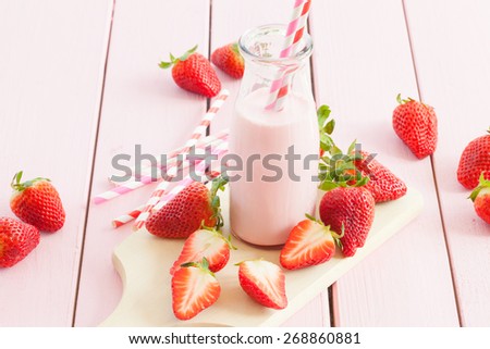 Vintage glass bottle with milk and fresh strawberries