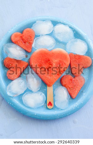 Watermelon lollipops in heart-shape on blue plate