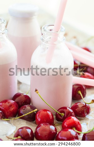 Creamy milk shake with fresh cherries on cold ice cubes